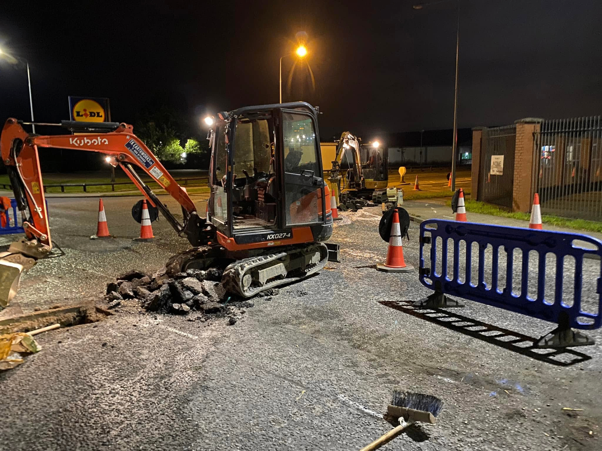 Kubota mini excavator on night-time road repair