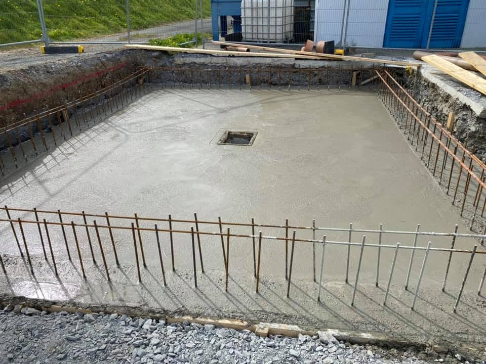 Freshly poured concrete pad with rebar starter bars